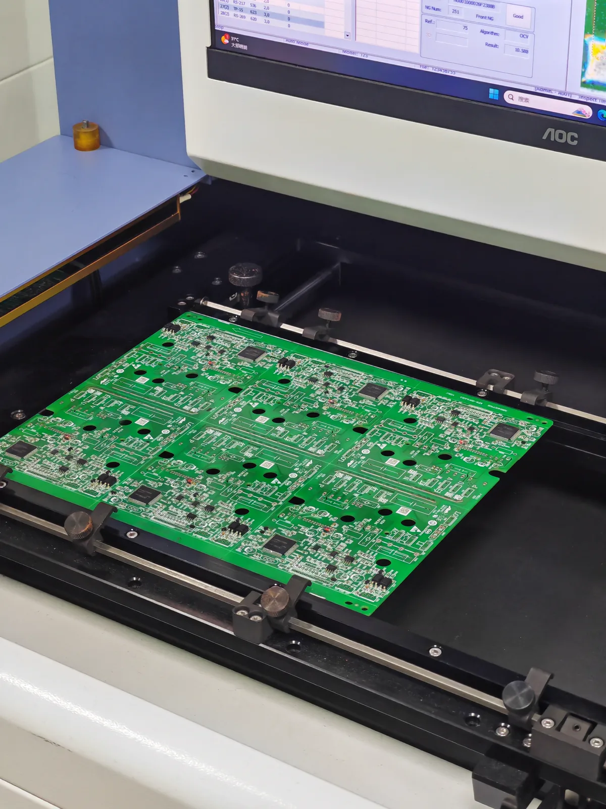 PCB clamped in an AOI inspection station
